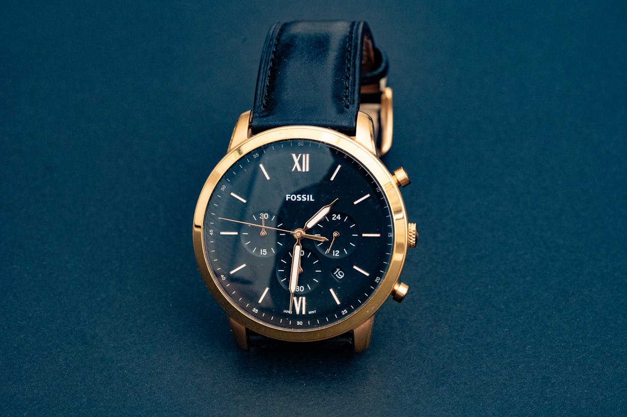 Home Luxury Fossil wristwatch with a black leather strap and gold casing, showcasing elegance and precision.
